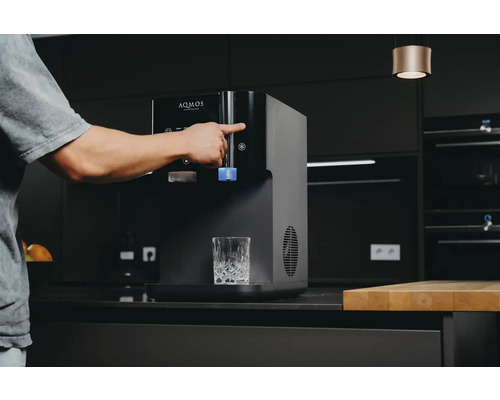 Distributeur d''eau Aqmos avec une personne remplissant un verre, dans une cuisine moderne