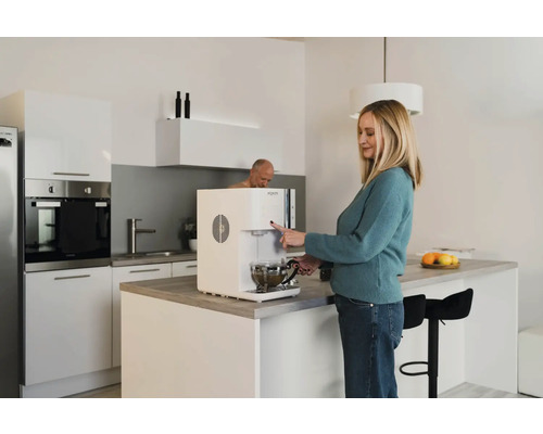 Femme utilisant un distributeur d''eau dans une cuisine lumineuse