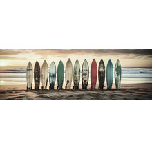 Plusieurs planches de surf sont alignées sur la plage.