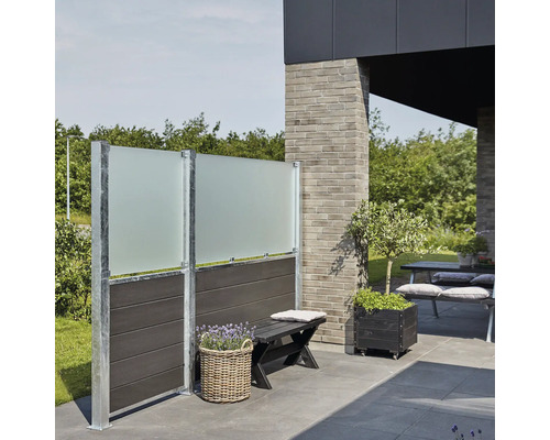 Scène avec un élément brise-vue en verre dépoli, un banc et un bac à plantes sur une terrasse