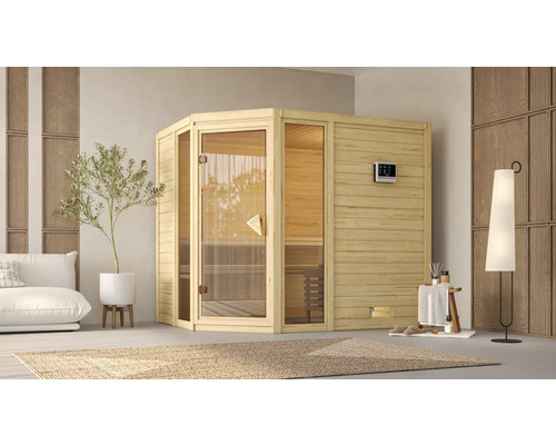 Sauna modulaire Karibu Tinai 3 avec poêle 9 kW et commande ext. sans couronne de toit avec porte tout en verre bronzé Sauna en bois avec porte en verre dans une pièce lumineuse avec canapé, plante et tapis