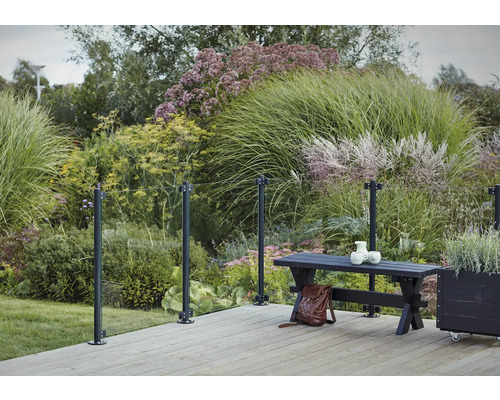 Scène de jardin avec garde-corps en verre, plancher en bois, banc et végétation luxuriante
