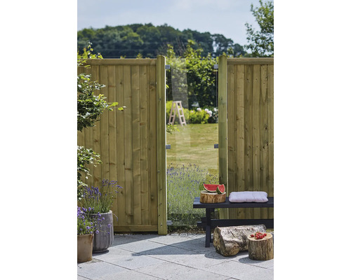 Scène de jardin avec clôture en bois, élément en verre et banc