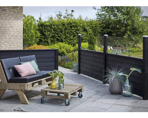 Extérieur avec terrasse en bois, mobilier de palettes et clôture en bois avec éléments en verre