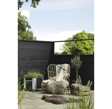 Scène de jardin avec clôture en bois, fauteuil en rotin avec fourrure et couverture, jardinière et olivier