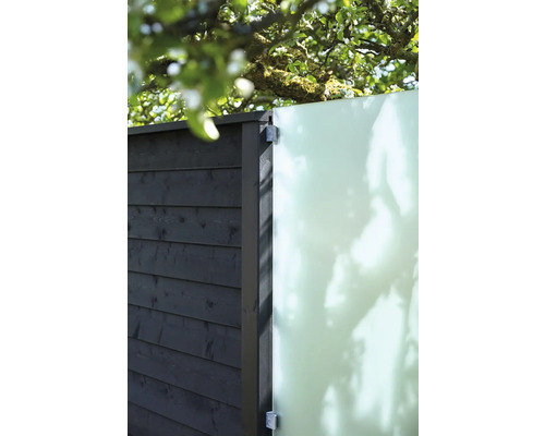 Vue détaillée d''une clôture de jardin avec des éléments en bois et un panneau de verre