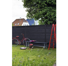 Scène de jardin avec clôture en bois, banc, échelle et vélo