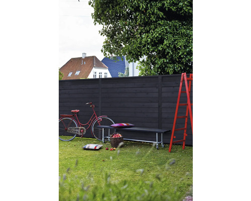 Scène de jardin avec clôture en bois, banc, échelle et vélo