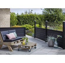 Gartenbereich mit Holzterrasse, Palettenmöbeln und Sichtschutzzaun aus Holz und Glas