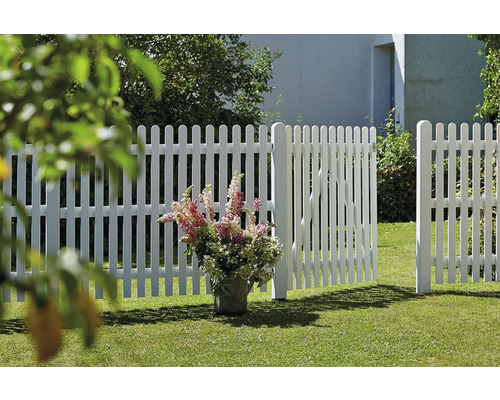 Weißer Lattenzaun mit geöffnetem Gartentor auf einer Rasenfläche
