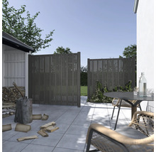 Scène de jardin avec éléments de clôture et coin salon sur une terrasse