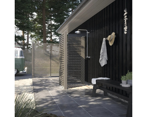 Douche extérieure avec mur en bois, banc et porte-serviettes dans le jardin