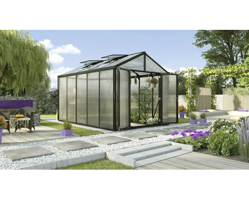 Serre avec portes ouvertes dans un jardin avec des plantes et du mobilier de jardin.
