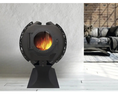 Runder Kaminofen mit Glasfenster und brennendem Feuer im Wohnzimmer.