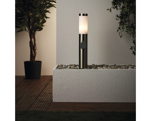 Luminaire extérieur sur des pierres dans une jardinière à côté de plantes