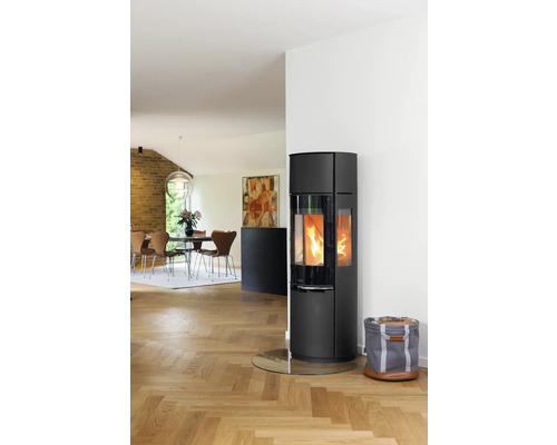 Salon avec poêle à bois, panier à bois de chauffage et table à manger