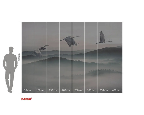 Papier peint photo avec des grues survolant un paysage montagneux