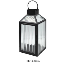 Windlicht aus schwarzem Metall mit geriffeltem Glas und Tragegriff, Maße 14 mal 14 mal 30 Zentimeter.