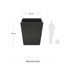 Quadratisches Tierra Verde Pflanzgefäß in Anthrazit, 30 Zentimeter breit, 33 Zentimeter hoch, mit Größenvergleich zu einer Person und Tierra Verde Logo.